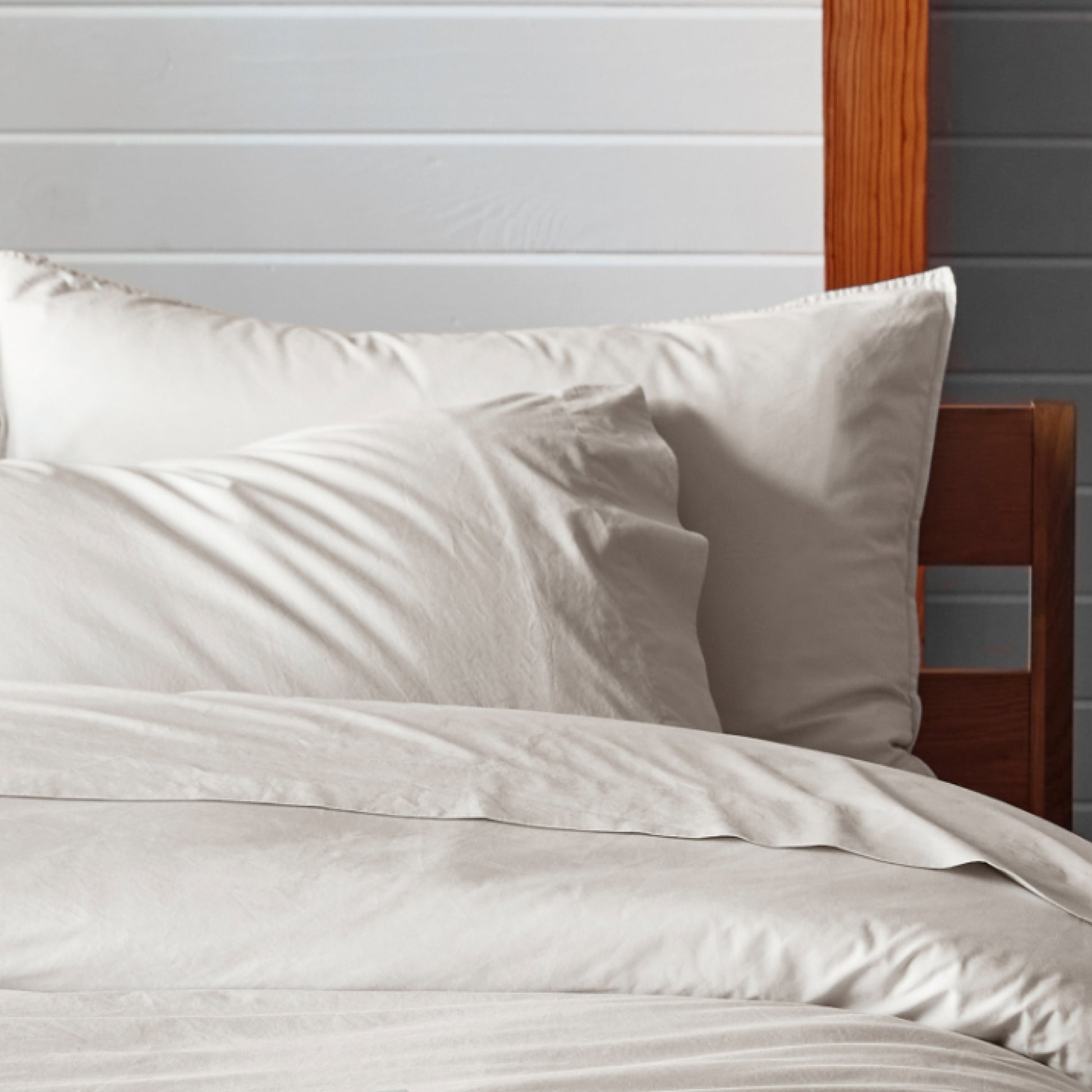 The Tuft and Needle Percale Pillowcase Set on a mattress in a bedroom||color:sand