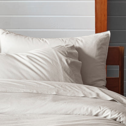 The Tuft and Needle Percale Pillowcase Set on a mattress in a bedroom||color:sand
