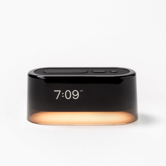 The Tuft and Needle Loftie Smart Alarm Clock with the night light on