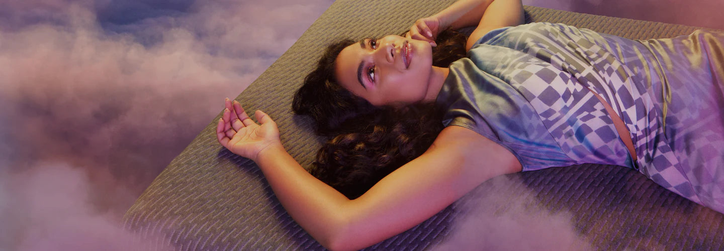 Woman laying on a mattress in the clouds 