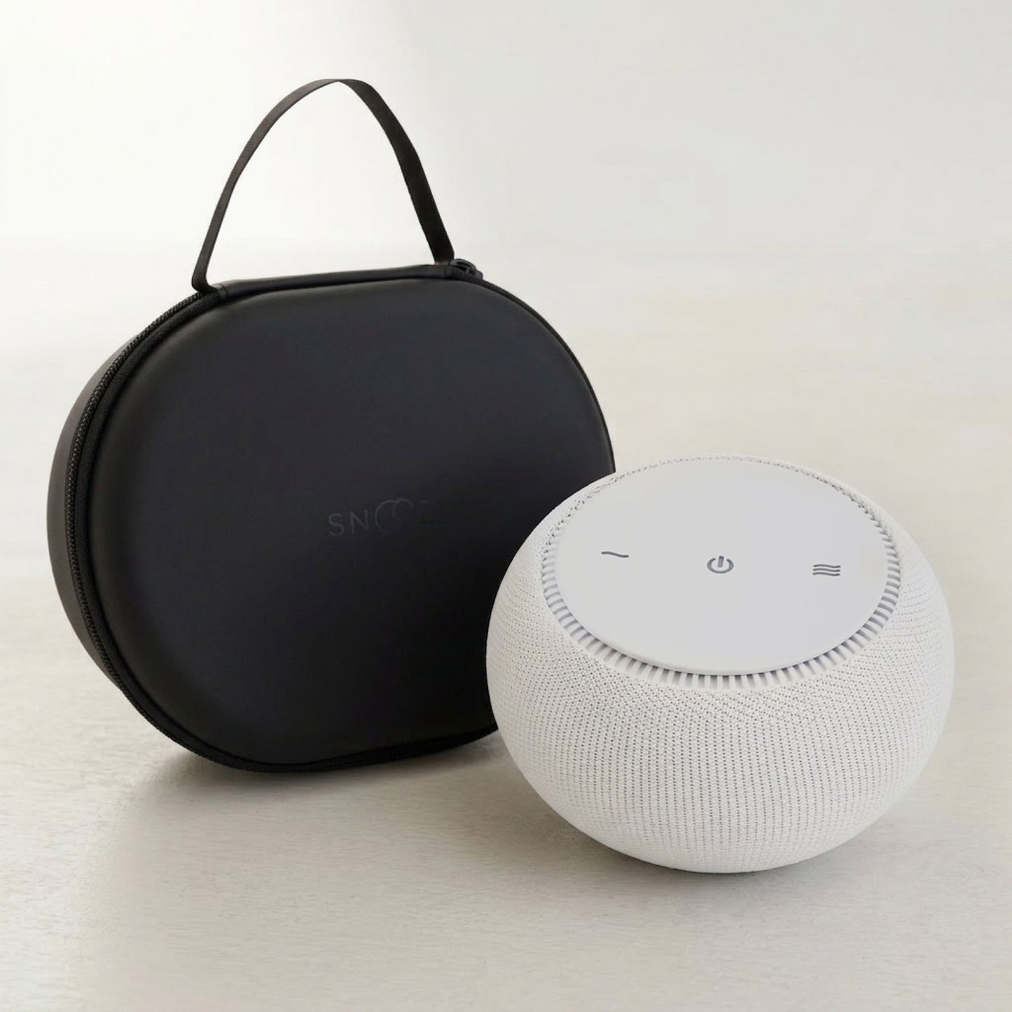 White smart speaker with black carrying case on a light background