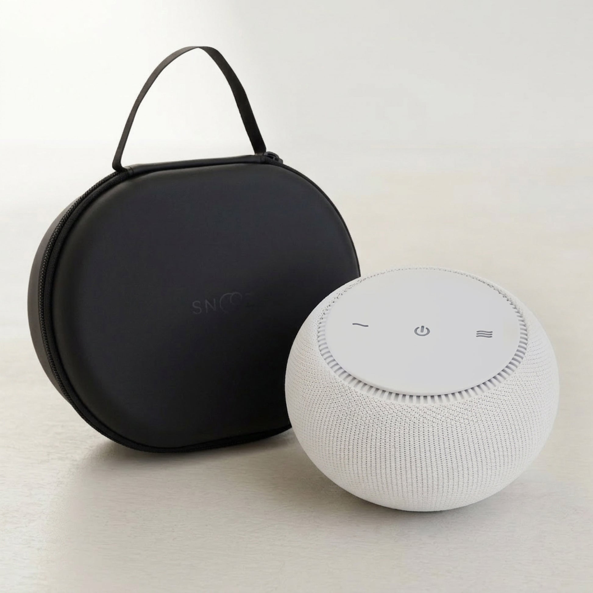 White smart speaker with black carrying case on a light background