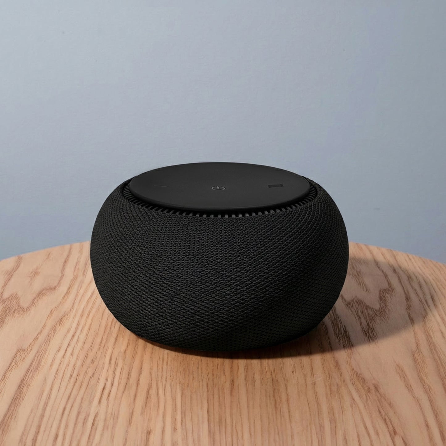 Black smart speaker on a wooden surface with a light blue background