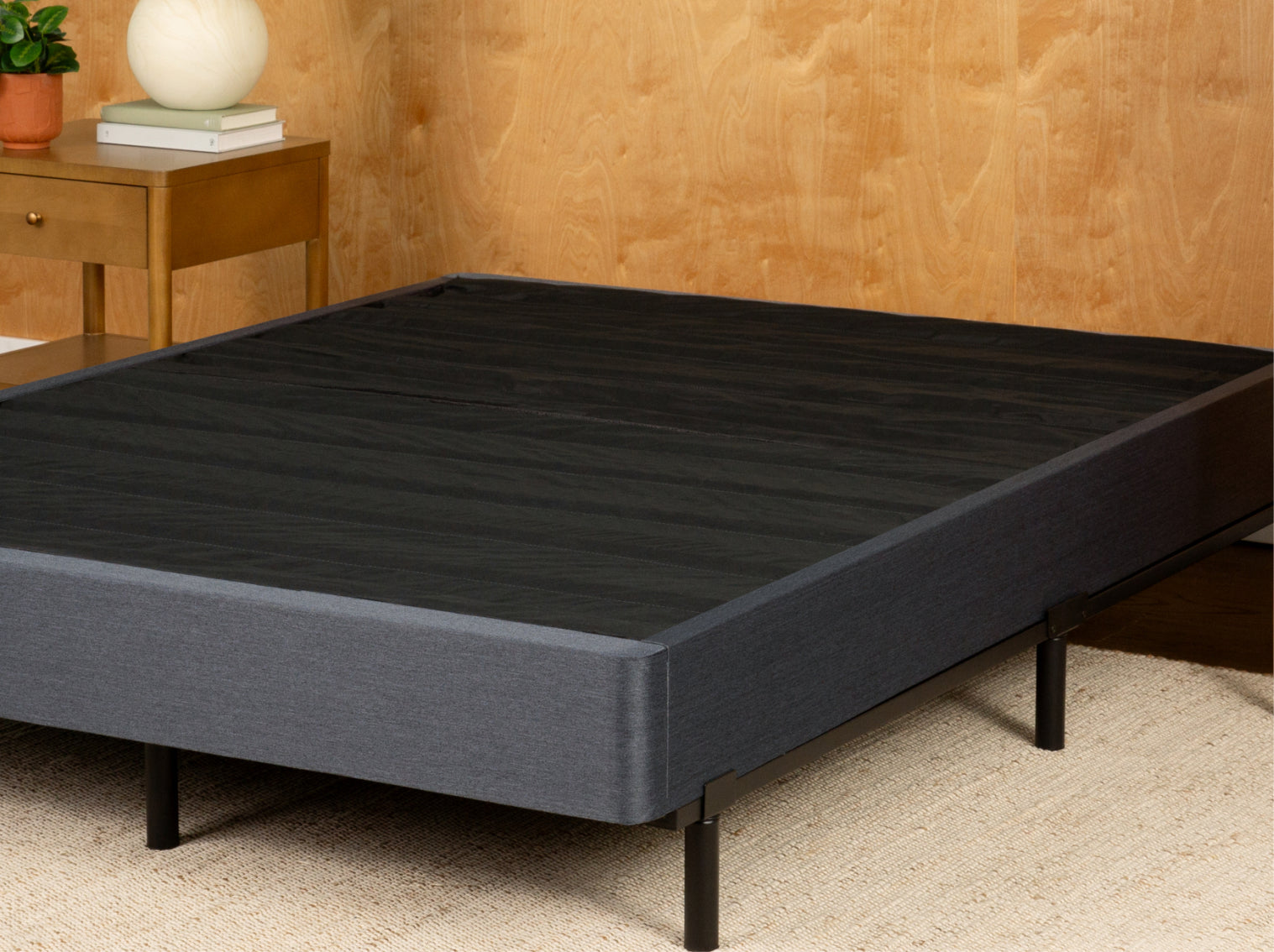 Tuft and Needle gray bed frame with wooden headboard and nightstand in a room setting