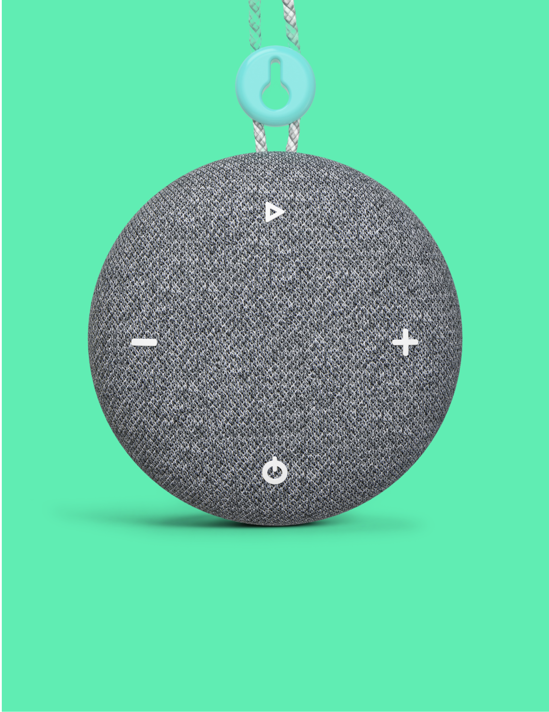 A round gray fabric-covered Tuft and Needle SNOOZ Go 2 Travel White Noise Sound Machine speaker with white control symbols on the front, hanging against a bright mint green background. A light blue key-shaped loop is attached at the top.