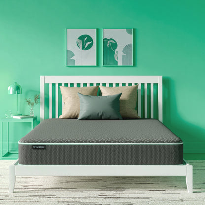 The Tuft and Needle Essential Hybrid Mattress in a green bedroom
