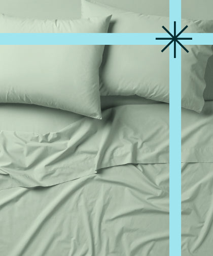 Tuft and Needle green bedding, two pillows encased in 2 green pillow cases on top of 2 sheets.