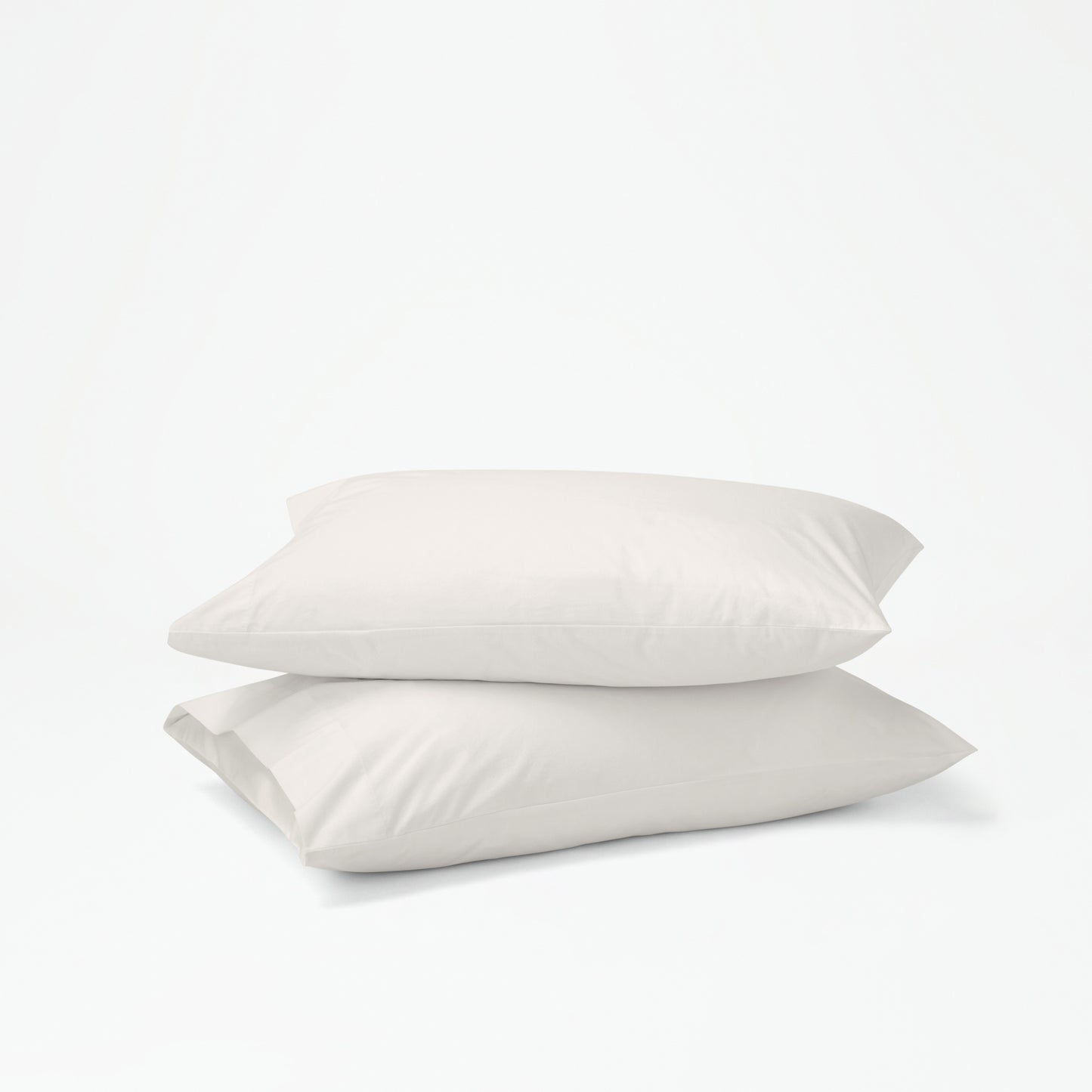 The Tuft and Needle Percale Pillowcase Set on two stacked pillows||color:sand
