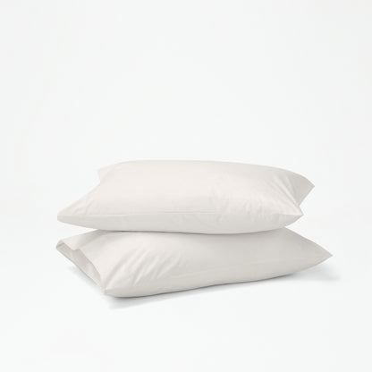 The Tuft and Needle Percale Pillowcase Set on two stacked pillows||color:sand