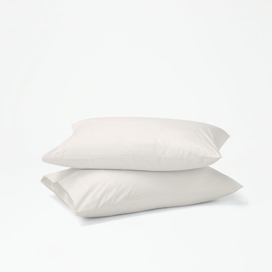 The Tuft and Needle Percale Pillowcase Set on two stacked pillows||color:sand