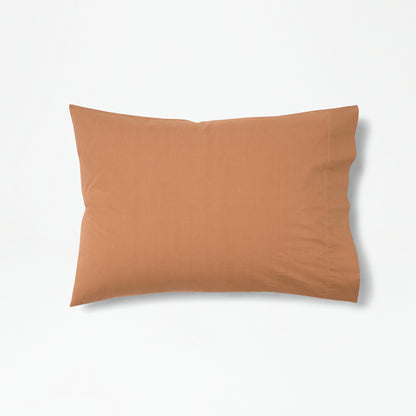 The Tuft and Needle Percale Pillowcase Set on one pillow||color:canyon