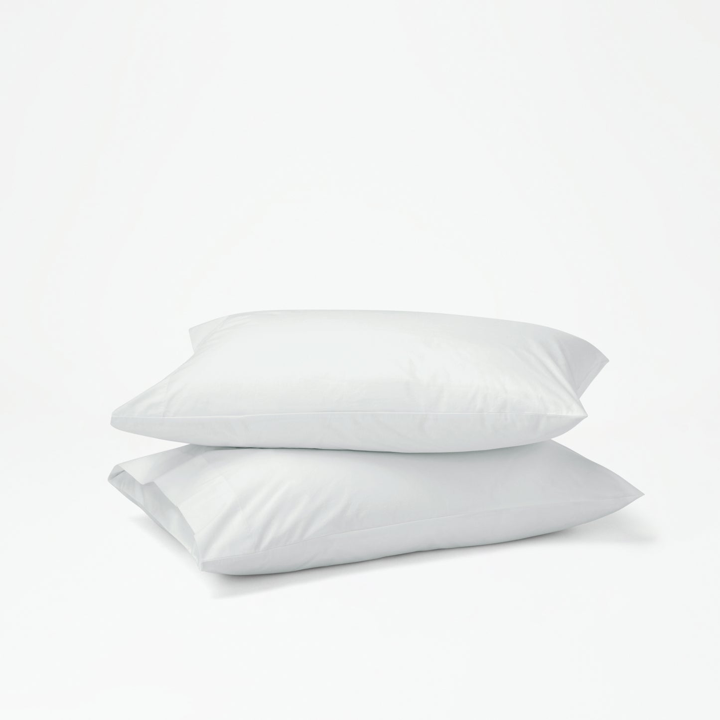 The Tuft and Needle Percale Pillowcase Set on two stacked pillows||color:glacier