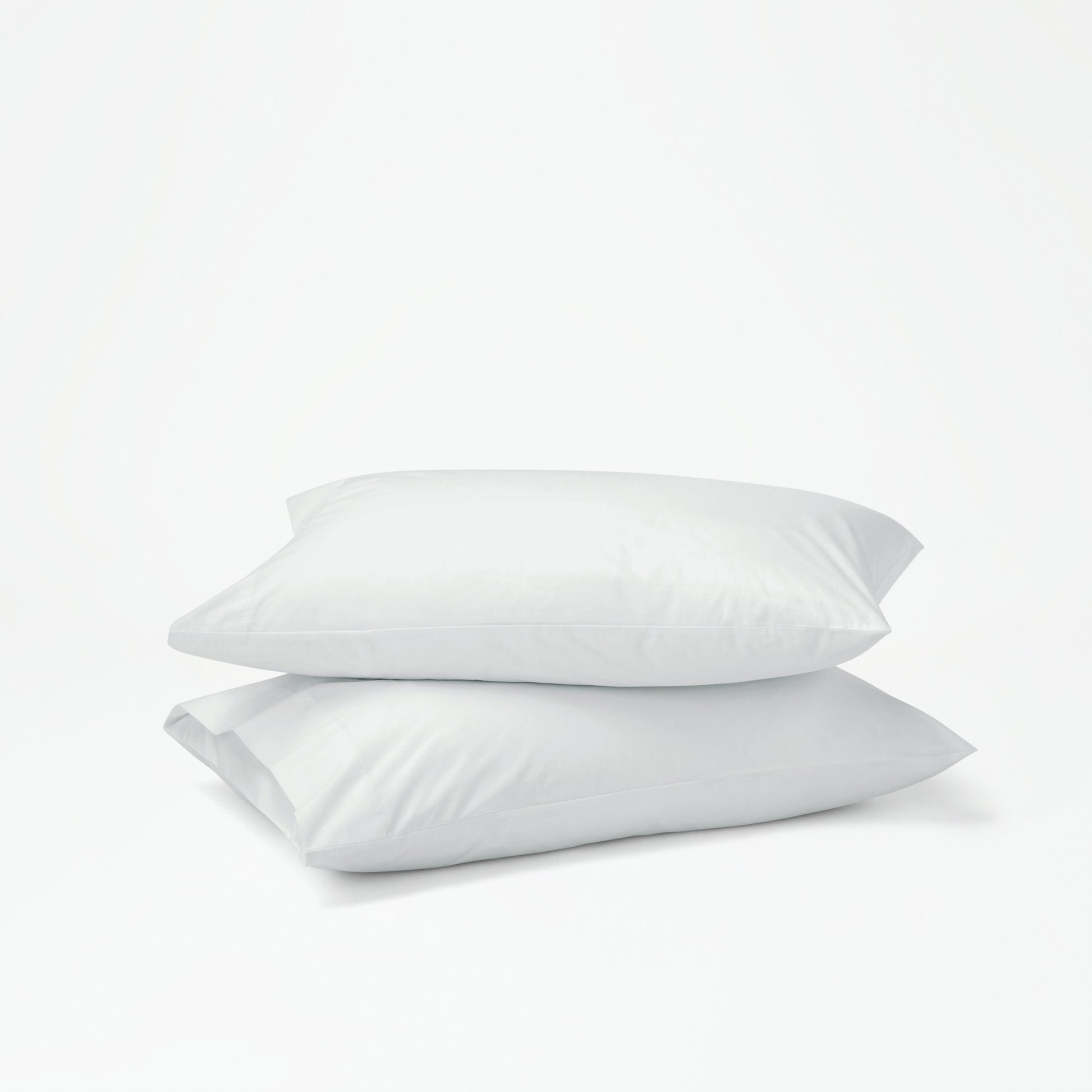 The Tuft and Needle Percale Pillowcase Set on two stacked pillows||color:glacier