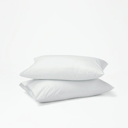 The Tuft and Needle Percale Pillowcase Set on two stacked pillows||color:glacier