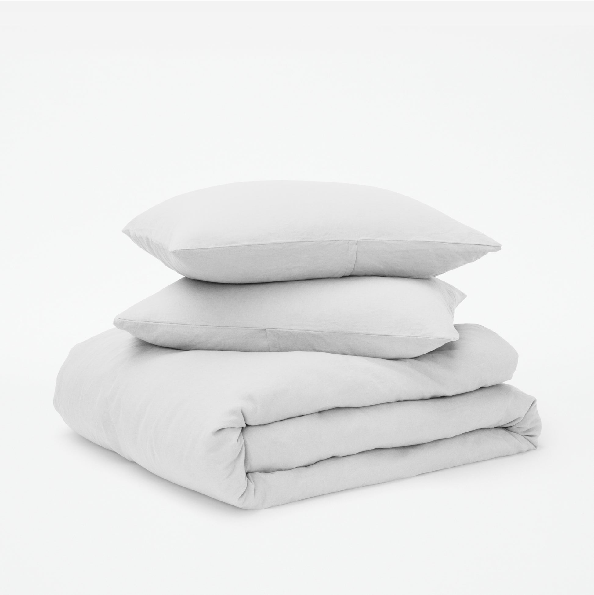 The Tuft and Needle Linen-Cotton Blend Duvet Set, 2 pillows stacked on 1 duvet covered blanket || color: Cloud
