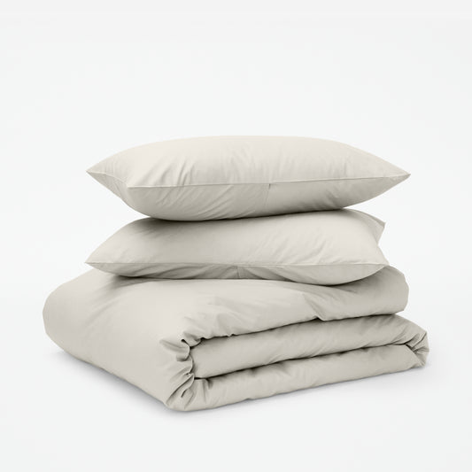 The Tuft and Needle Classic Percale Duvet Set, two pillows stacked on top of a sheet set || color: Sand
