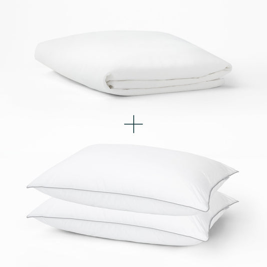 Tuft and Needle Mattress Protector and 2 down alternative pillows on top of each other with a plus sign in the middle