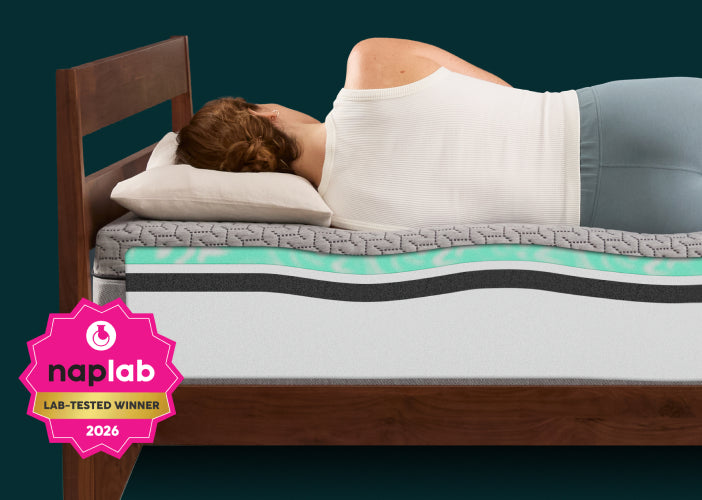 Woman laying on a Tuft and Needle mattress with a naplab award badge saying winner.