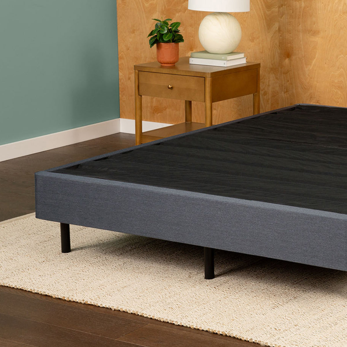 Tuft and Needle Bed Frame sitting on top of a cream rug