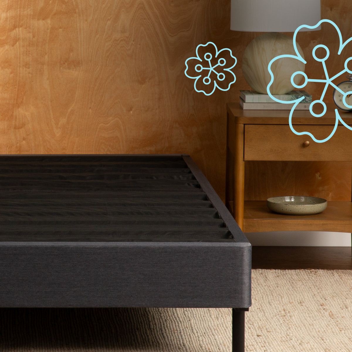 Dark gray Tuft and Needle bed frame against a wooden headboard with decorative elements.