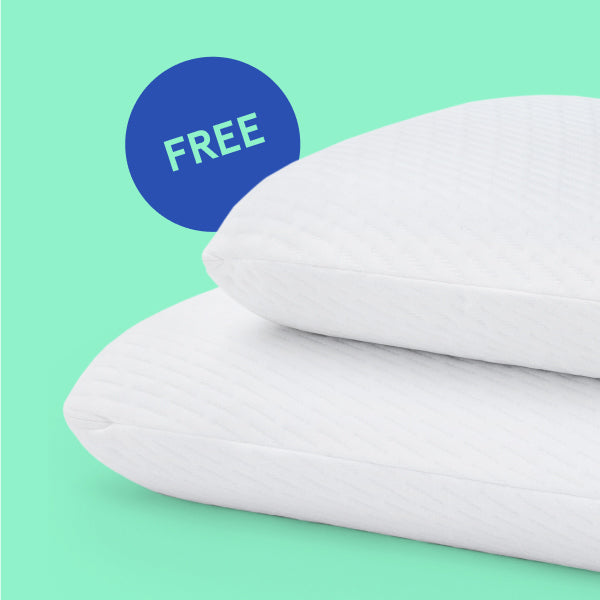 Two Tuft & Needle white pillows on a green background with a blue 'FREE' label.