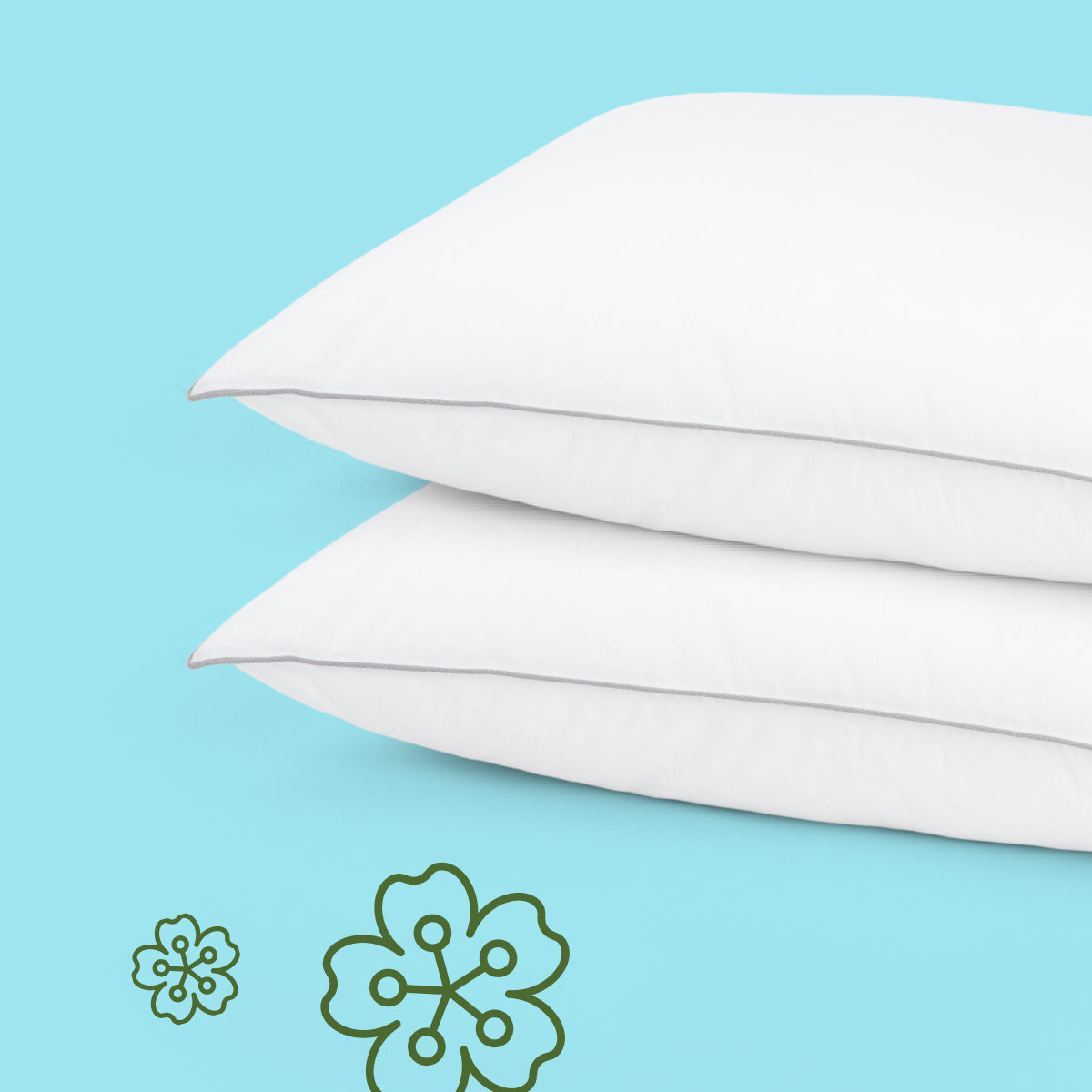 Two white Tuft & Needle pillows on a light blue background with floral icons.