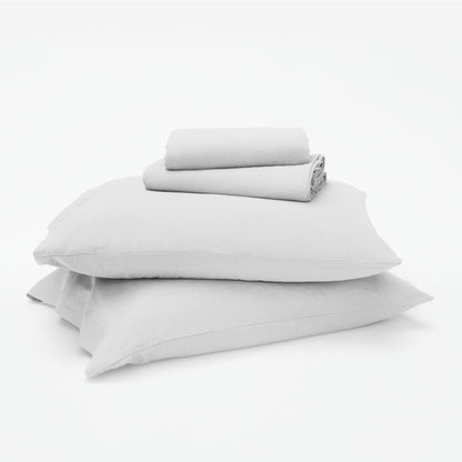 The Tuft and Needle Linen-Cotton Blend Sheet Set, 2 sheets stacked on 2 pillows || color: Cloud
