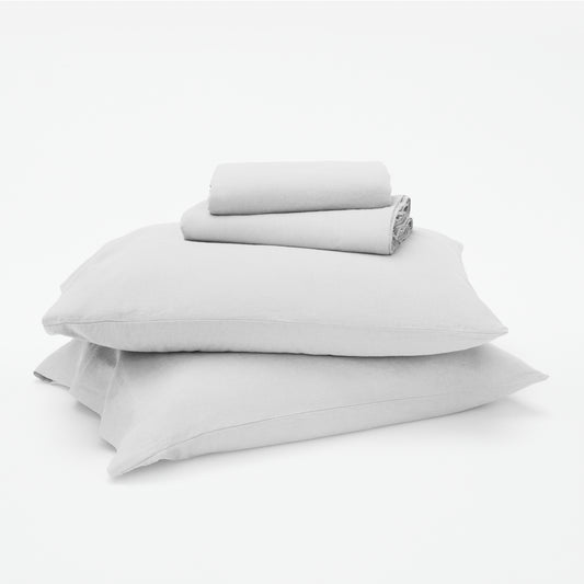 The Tuft and Needle Linen-Cotton Blend Sheet Set, 2 sheets stacked on 2 pillows || color: Cloud
