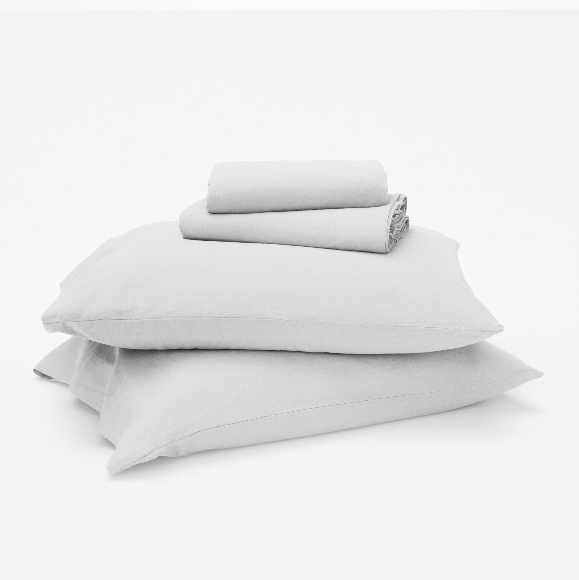 The Tuft and Needle Linen-Cotton Blend Sheet Set, 2 sheets stacked on 2 pillows || color: Cloud

