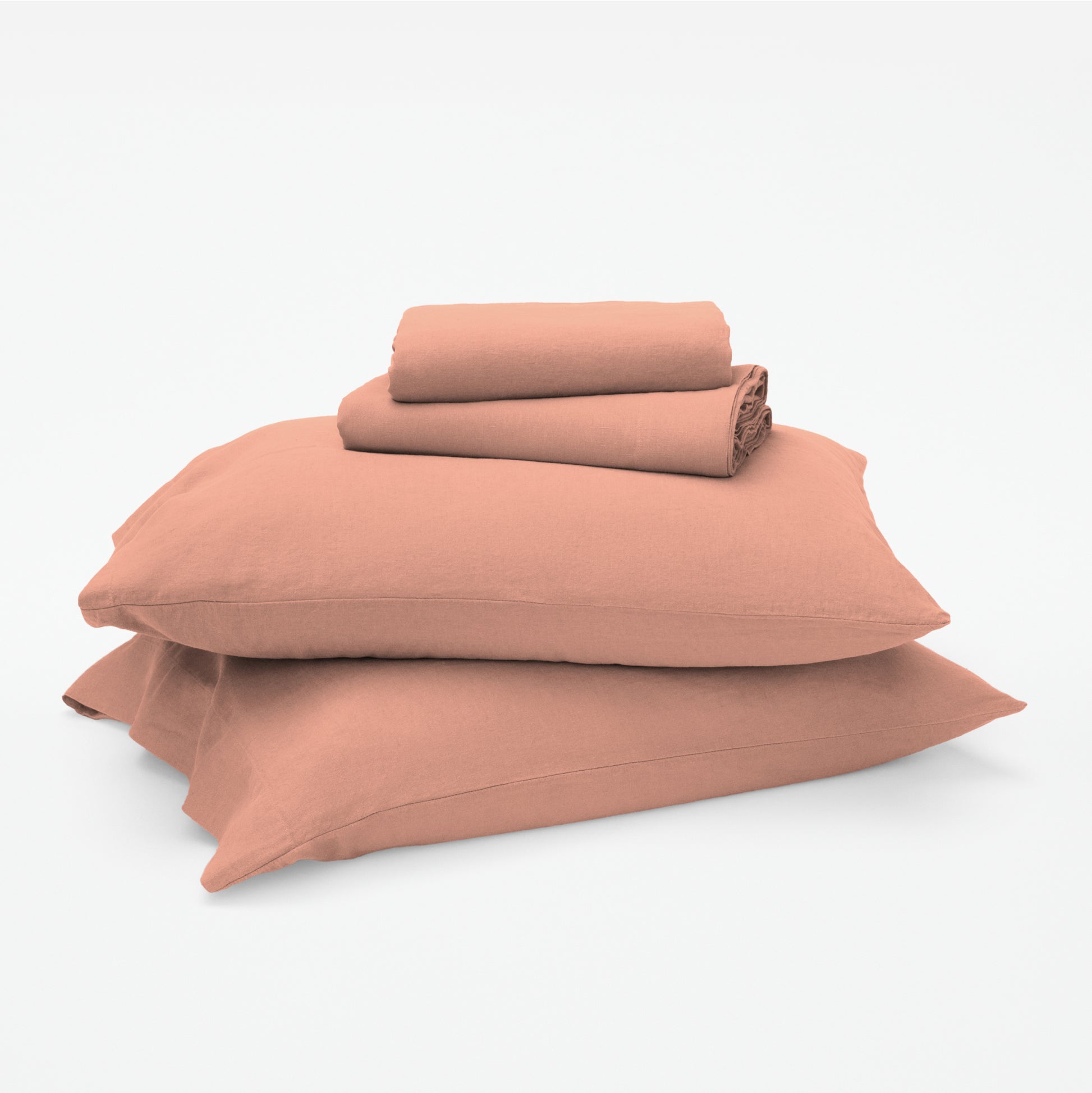 The Tuft and Needle Linen-Cotton Blend Sheet Set, 2 sheets stacked on 2 pillows || color: Muted Clay