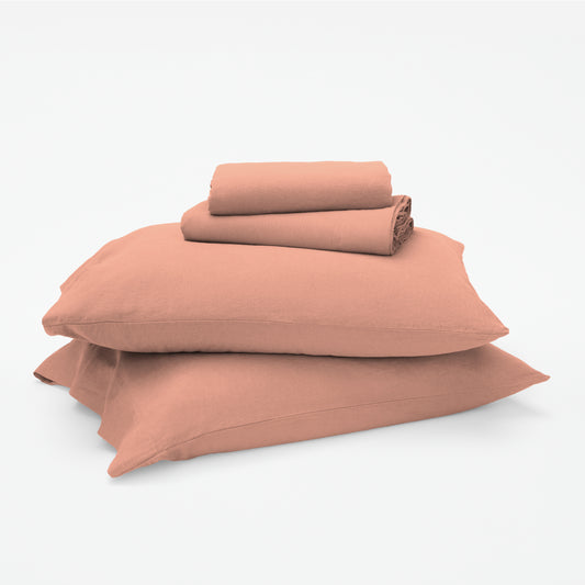 The Tuft and Needle Linen-Cotton Blend Sheet Set, 2 sheets stacked on 2 pillows || color: Muted Clay