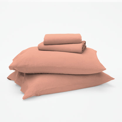 The Tuft and Needle Linen-Cotton Blend Sheet Set, 2 sheets stacked on 2 pillows || color: Muted Clay
