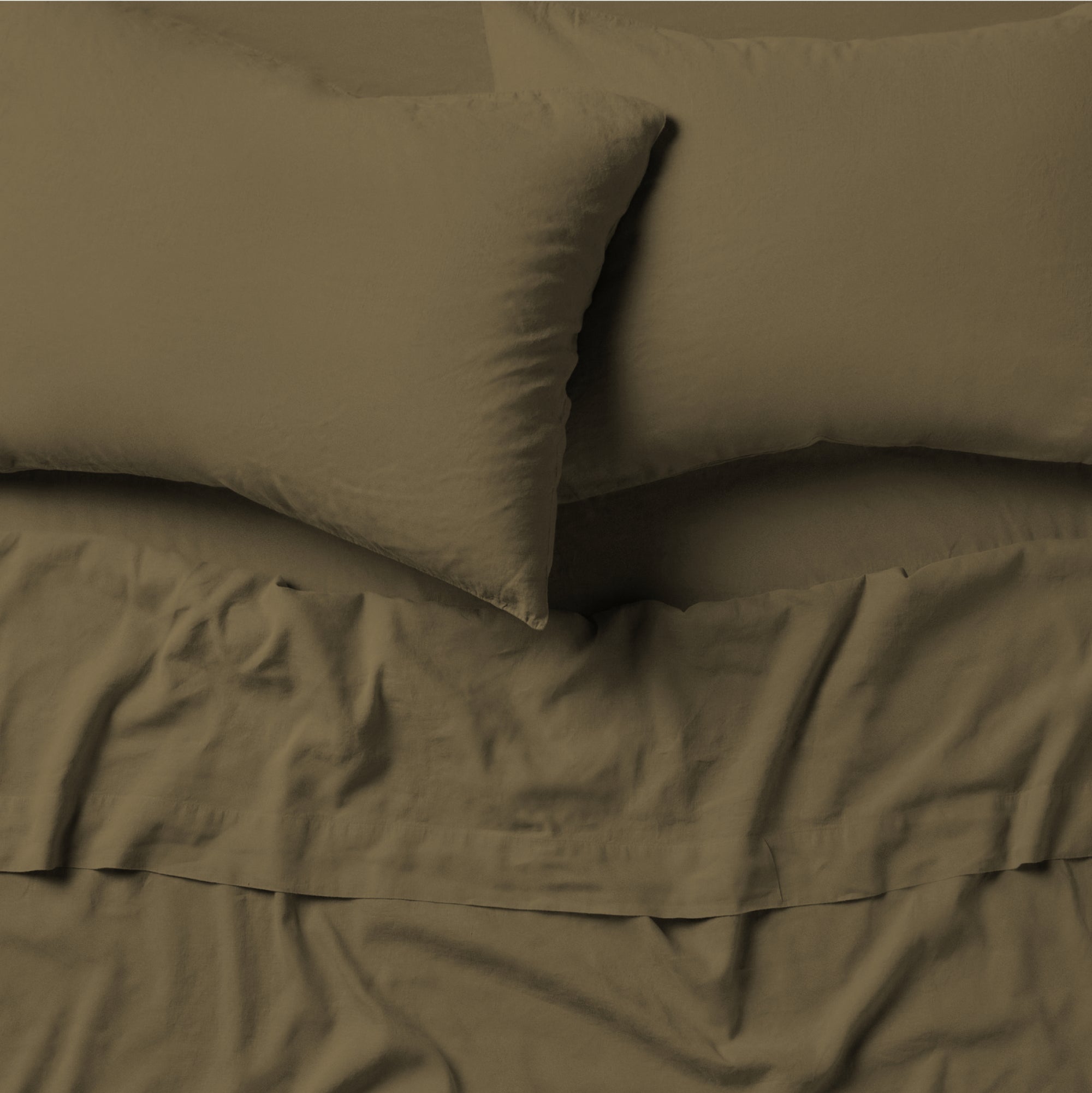 The Tuft and Needle Linen-Cotton Blend Sheet Set, 2 pillows on top of a sheet on a mattress || color: Martini Olive
