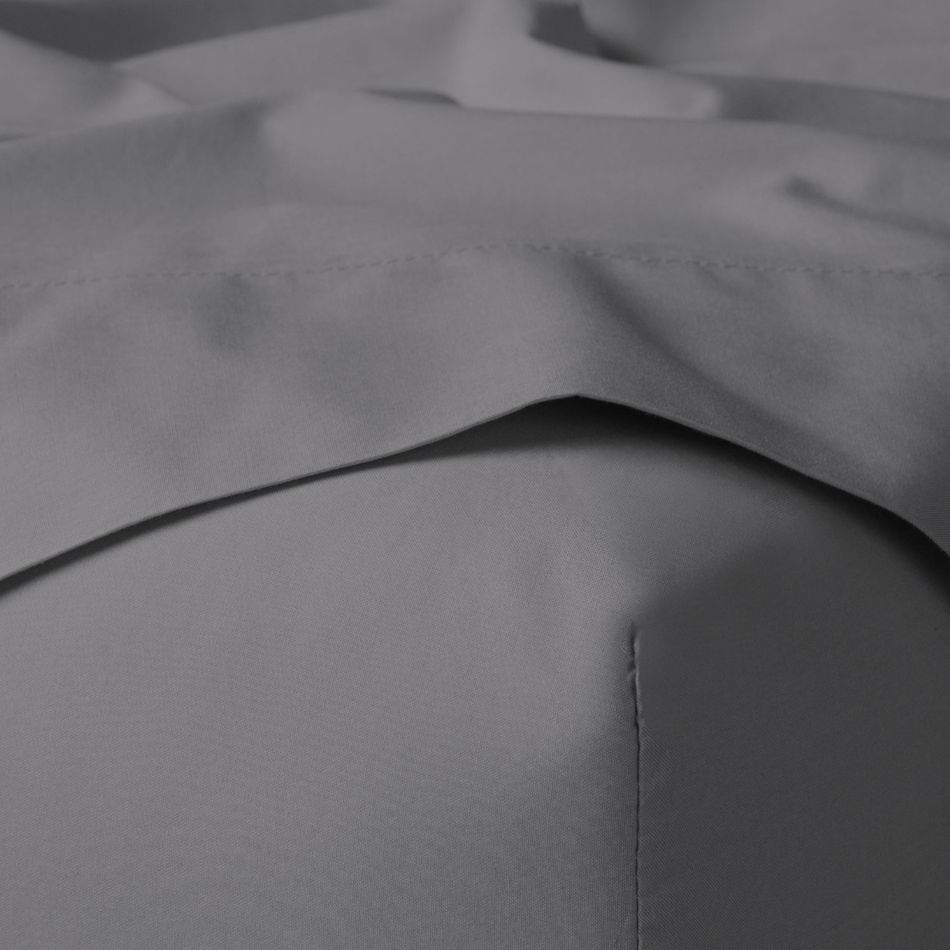 The Tuft and Needle Classic Percale Sheet Set, corner of a mattress with both sheets showing || color: Gray Quill
