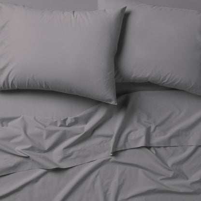 The Tuft and Needle Classic Percale Sheet Set, 2 pillows on top of a sheet on a mattress || color: Gray Quill
