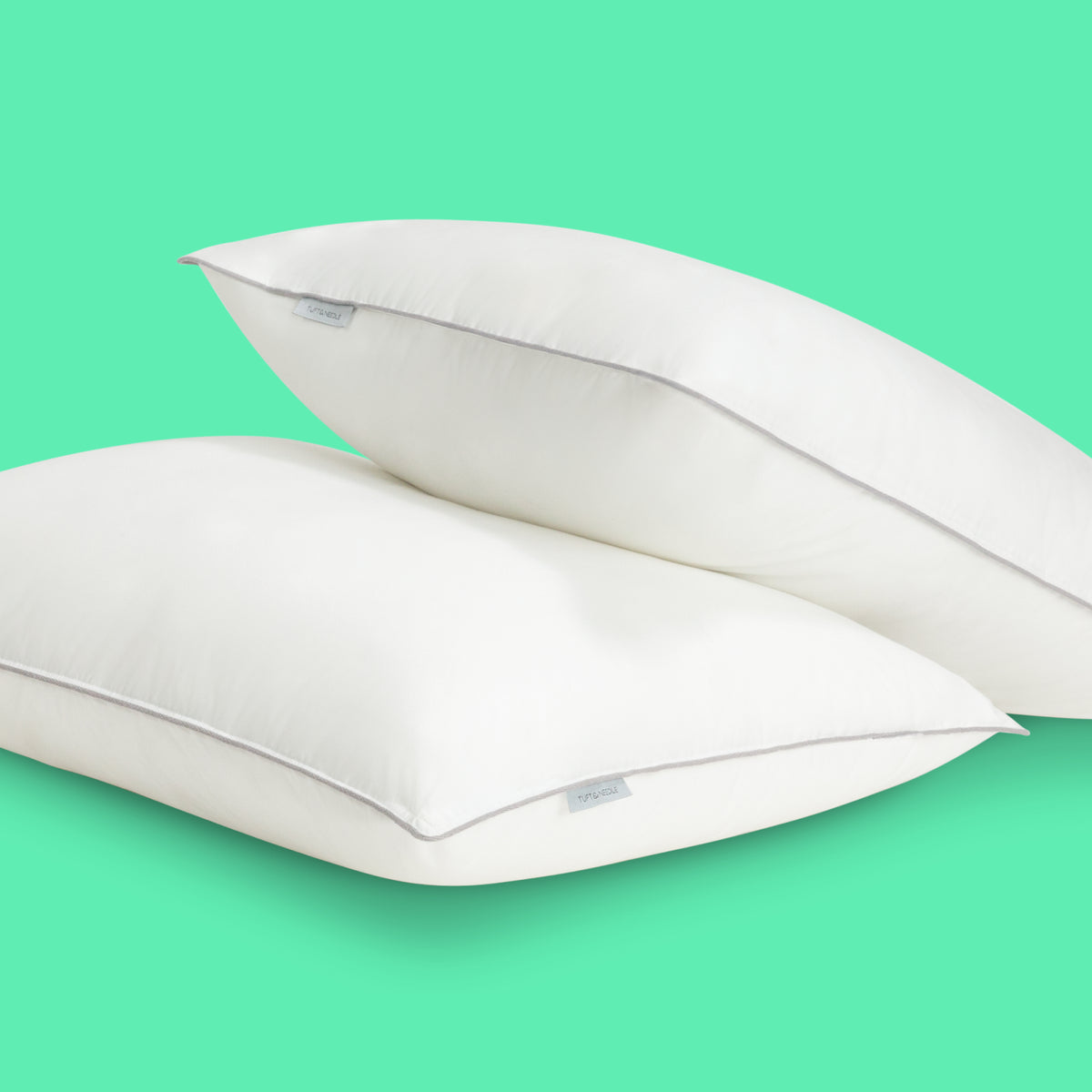 Tuft and Needle pillows on a green background