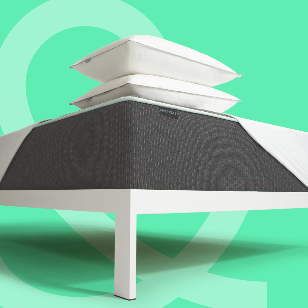 Tuft and Needle Mint mattress II with pillows and a mattress protector stacked.