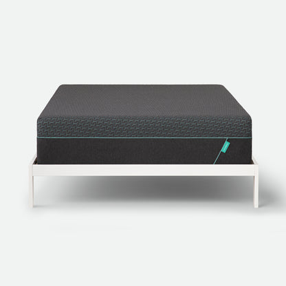 Tuft & Needle Black mattress on a white stand against a light gray background