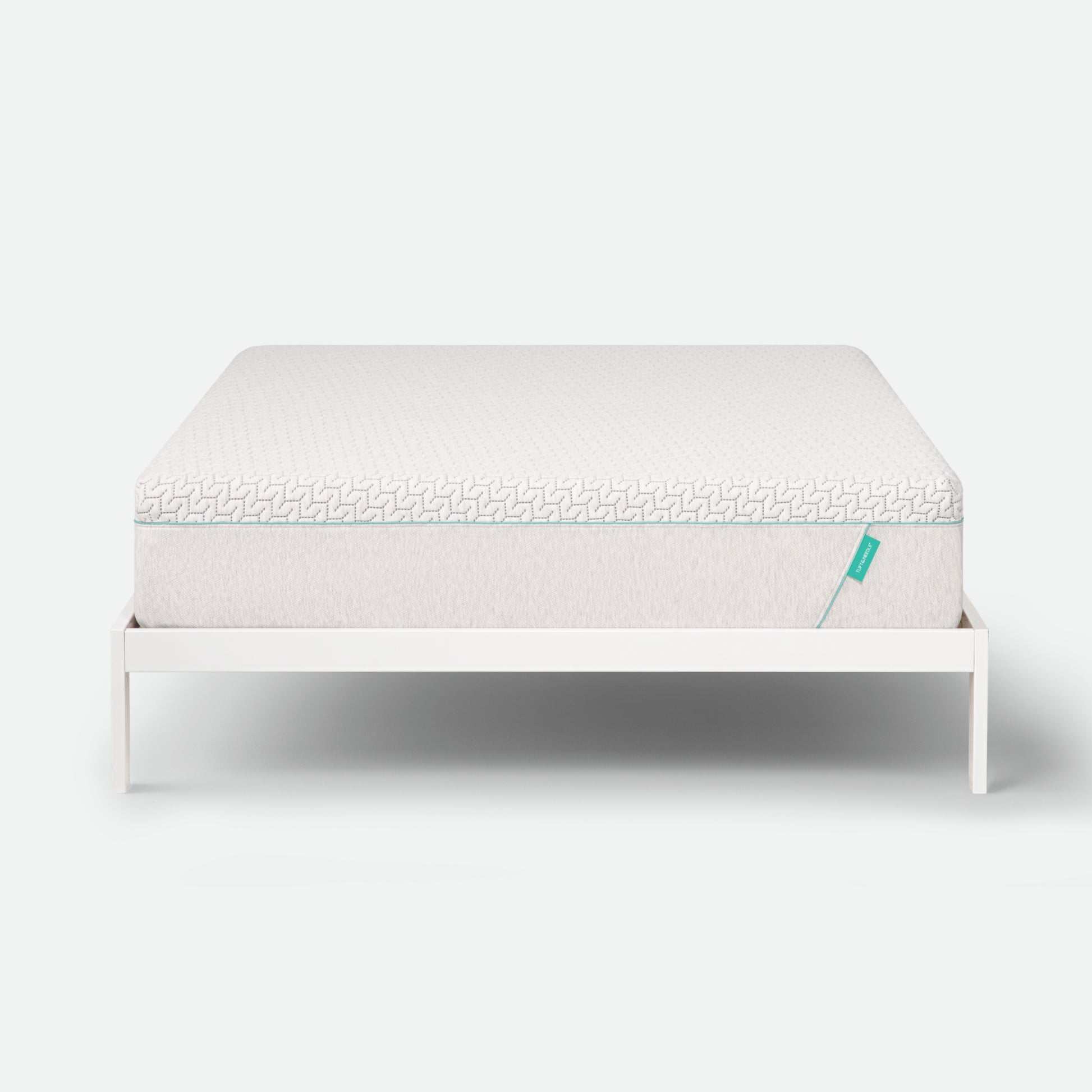 Tuft & Needle Mattress on a white stand with a white background