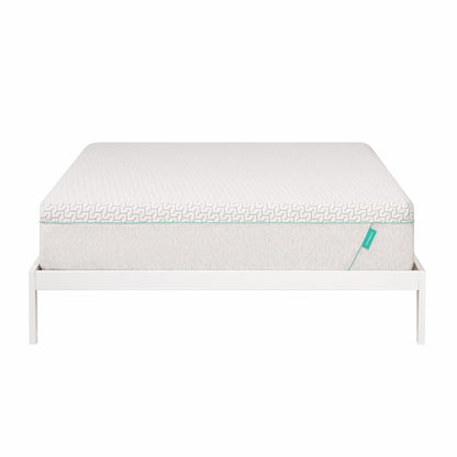 Hybrid mattress sits on white bed frame.