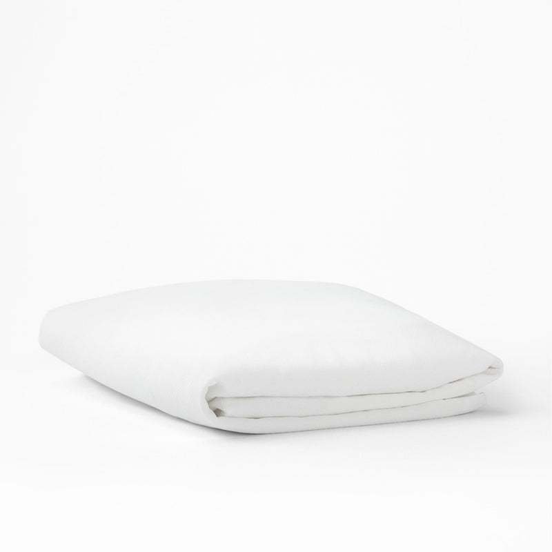 The Tuft and Needle Mattress Protector folded on a white background