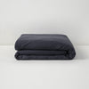 The Tuft and Needle Linen Duvet Cover folded on a white background||color:charcoal