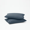 The Tuft and Needle Percale Pillowcase Set on two stacked pillows||color:slate