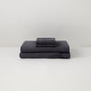 The Tuft and Needle Linen Sheet Set folded and stacked ||color:charcoal