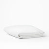 The Tuft and Needle Mattress Protector folded on a white background